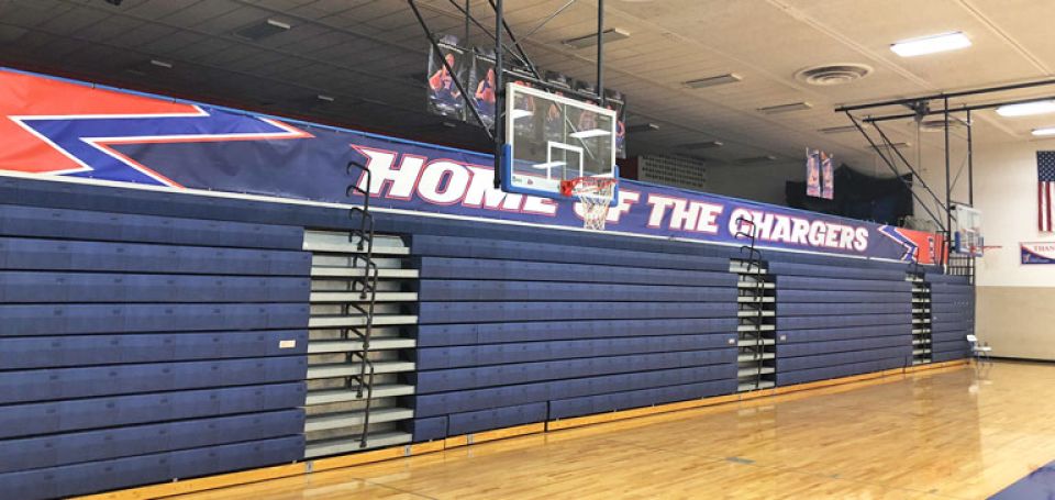 home of the chargers banner over gym bleachers